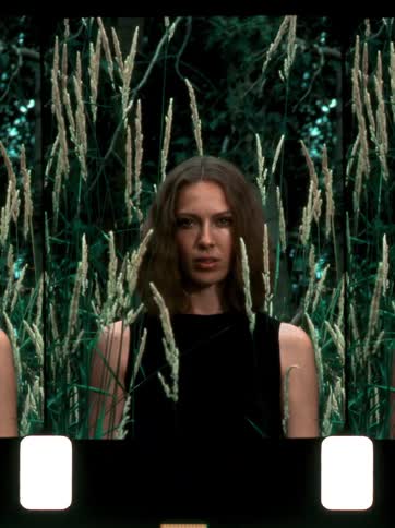 Woman model in black dress amidst nature of green trees