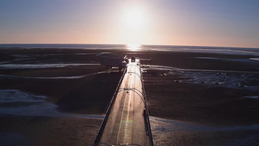 A long bridge goes out over a field