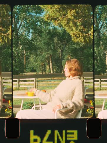 A woman is sitting in her yard drinking orange juice
