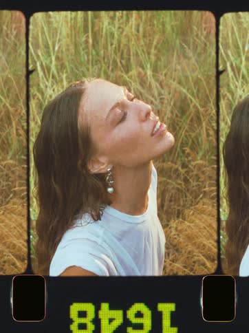 Close up portrait of woman looking into the sky as it rains while standing outdoors during daytime