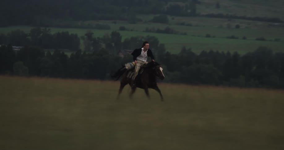 Man leading a horse at high speed through a field