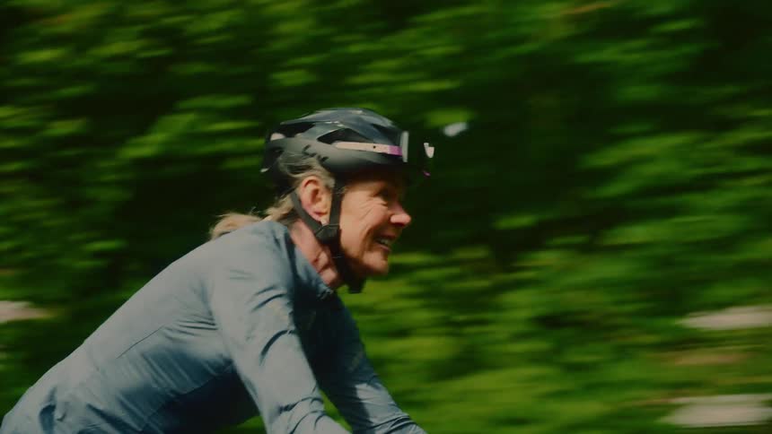 Happy female cyclist cycling in a wooded environment