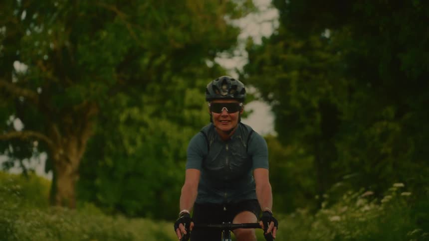 A woman bikes down a path