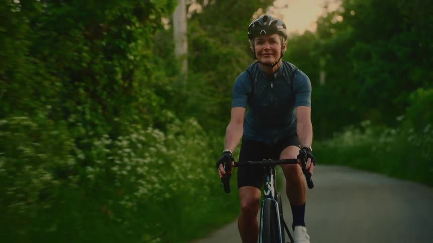 Woman with happy expression and cycling outfit cycling outdoors