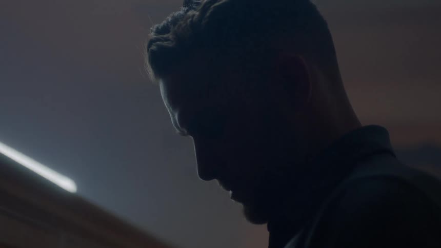 A man is looking down in a dark room