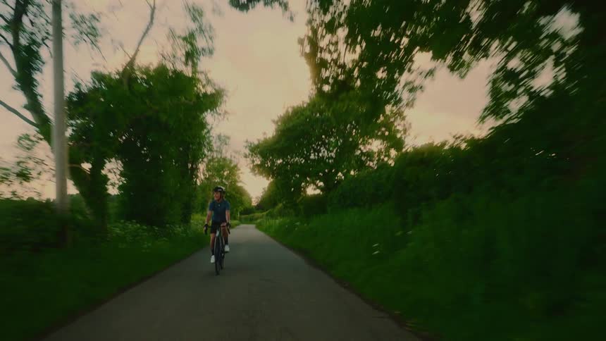 Cyclist on a paved area surrounded by vegetation