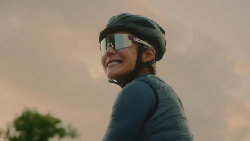 Cyclists pause near a meadow under an overcast sky