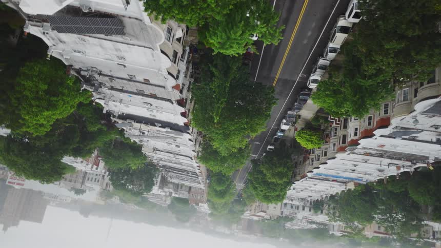 Aerial view of a quiet urban neighborhood street lined with trees and buildings