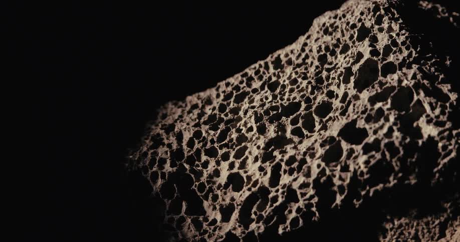 Rock with holes against a black background