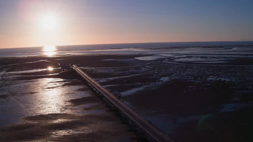 A long pier at dawn and low tide