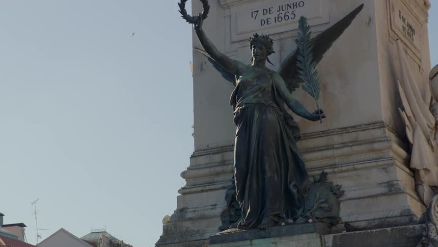 Statue of an angel holding a quill and wreath