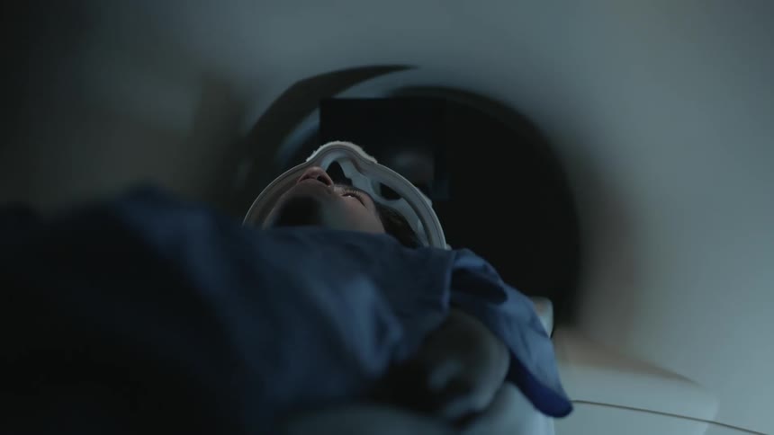 A person is slowly sliding into a tube