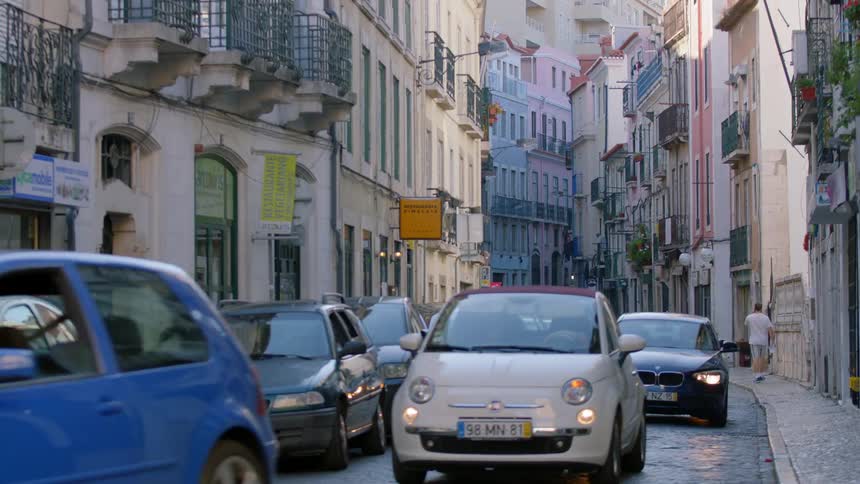 Traffic on a narrow road between buildings