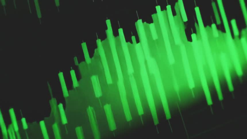 Close up of a device screen displaying a trading interface in green over a dark background