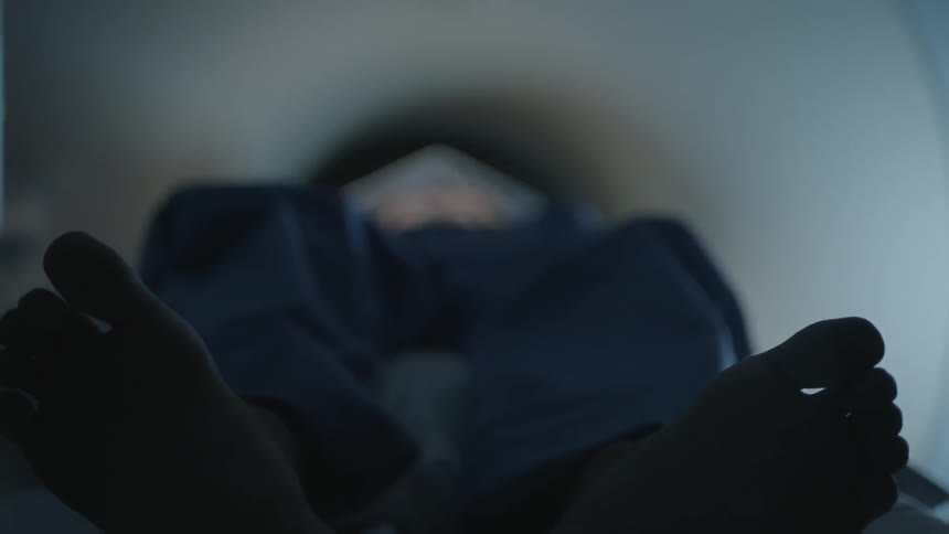 A man lies on a medical imaging machine