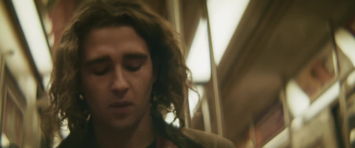Man looking down while inside a moving train