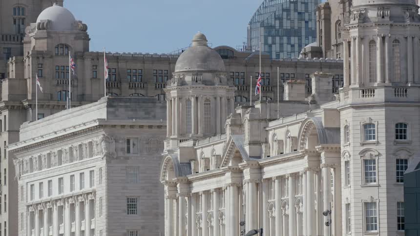 Flags wave in the air atop a building