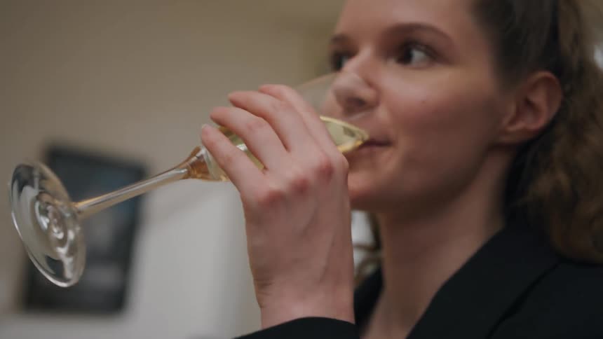 Woman toasting and drinking a glass of champagne