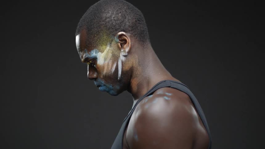 A man with face paint is looking down