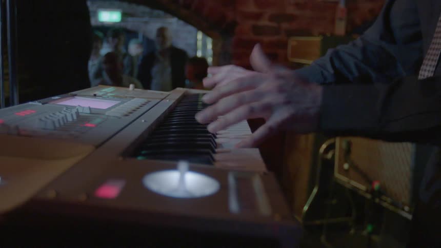 Person playing a piano at a nightclub