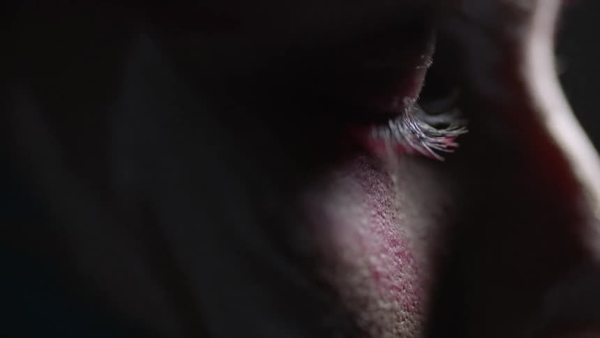 A woman's eye blinks open