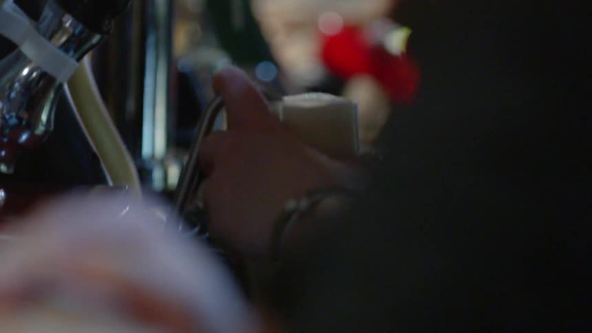 A restaurant worker pours beer into a glass