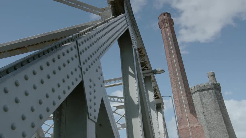 Clouds floating over a steel bridge and brick structures