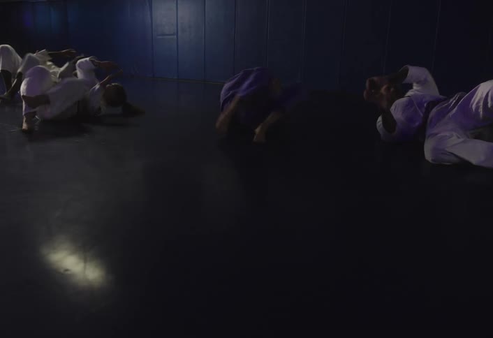 Students lying on the floor doing jiujitsu training