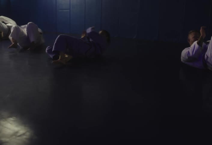 The people are rolling around on the mats in the gym