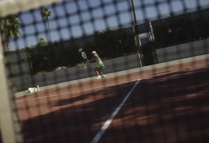 A woman runs and hits the tennis ball