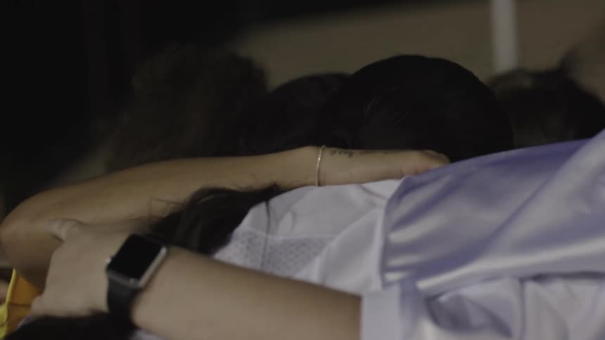 A group of women gathers for a group hug