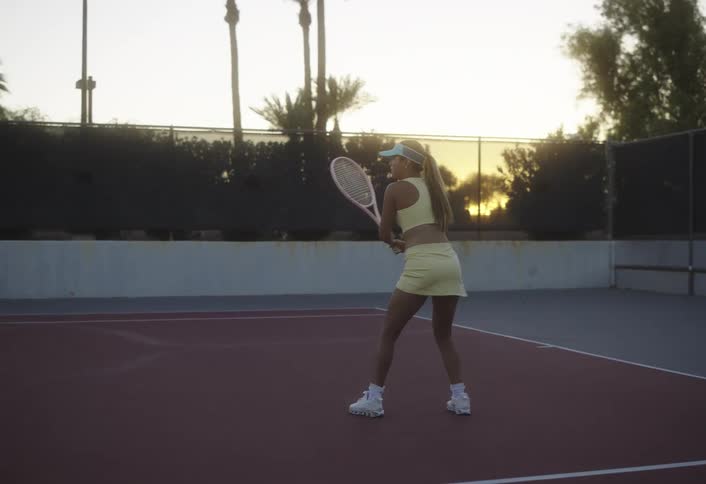 A tennis player plays tennis on the court