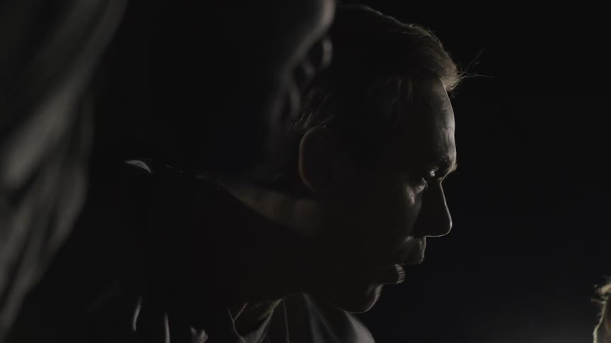 A man is talking in a huddle at night