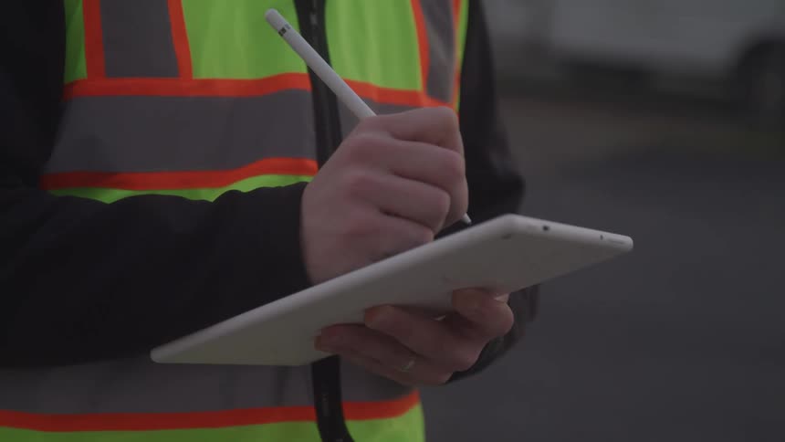 A man is writing on his tablet with a stylus