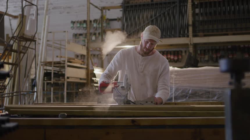 Man using a circular saw to cut wood in a workshop