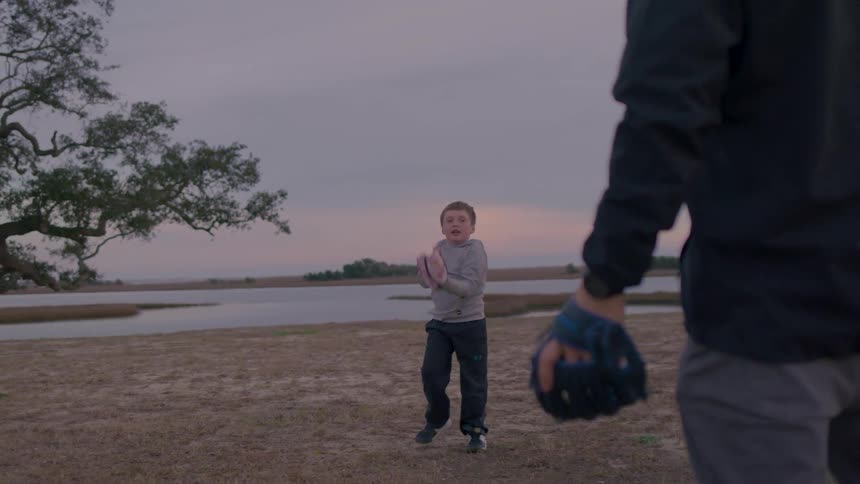 A father and son are playing catch