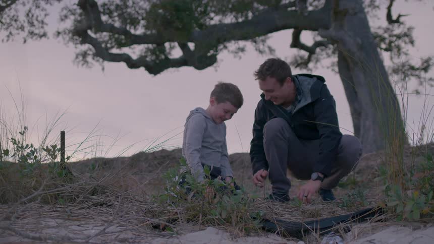 A father and son pick up sticks