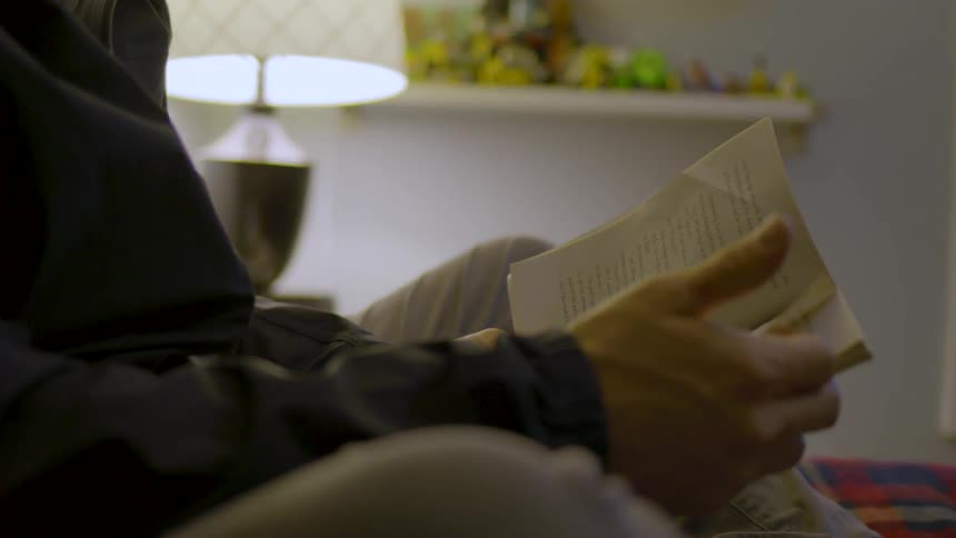A person is sitting in bed reading