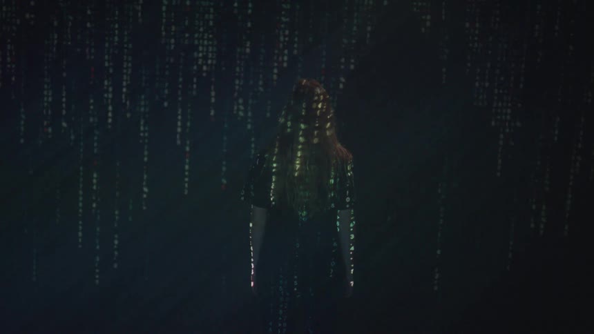 A projection light is on the woman facing the wall