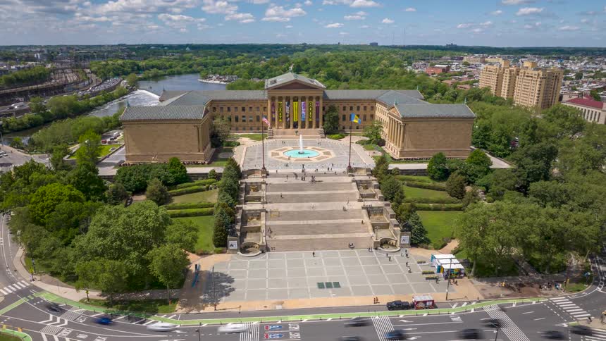 A wide aerial hyperlapse of the Philadelphia Museum of Art with its iconic steps and surrounding greenery