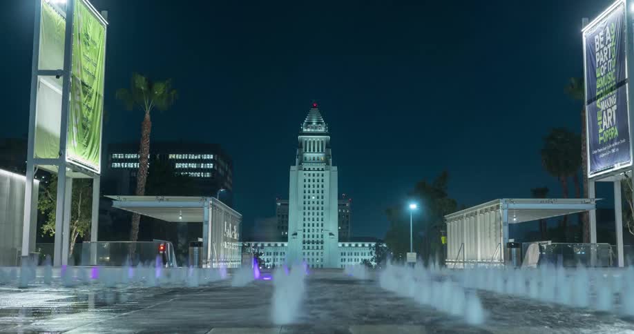 The large fountain shoots water up at night in Grand Park and Los Angeles City Hall