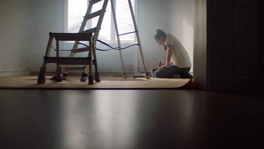 A woman stirs a can of paint