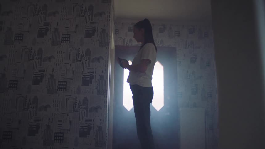 A woman puts tape on the wall