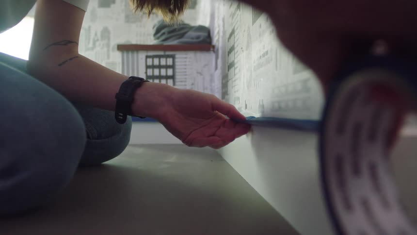 Woman placing a blue ribbon in a room of the house