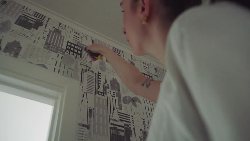 A woman puts spackle on the wall