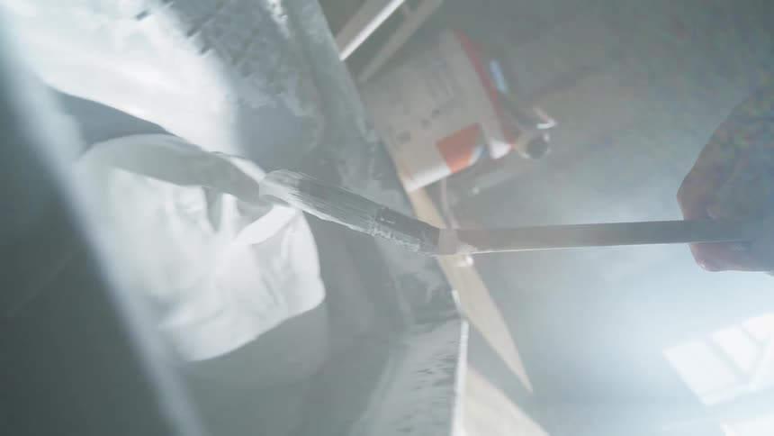 The paint brush is dipped into white paint