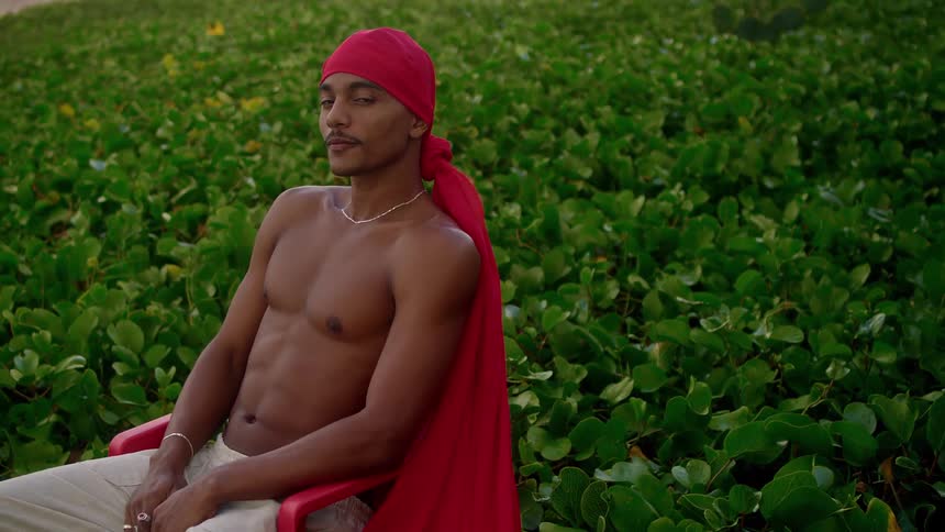 A man wearing a red do rag smiles