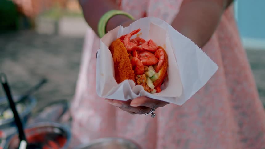A woman shows off food outside