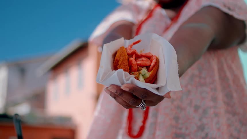 A woman hands out a food sample