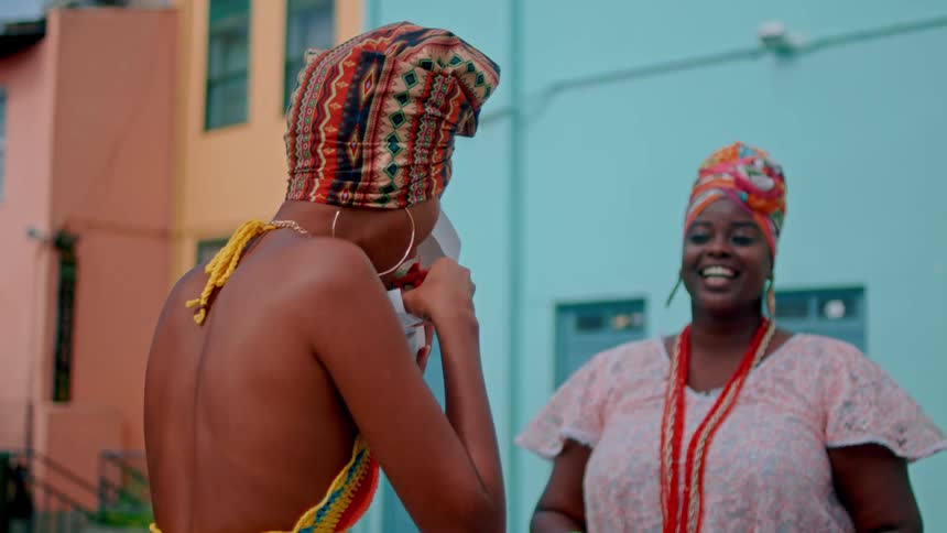 A woman laughs as another eats